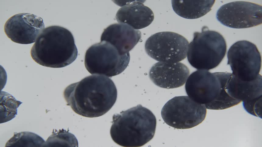 Blueberries are being dropped into water