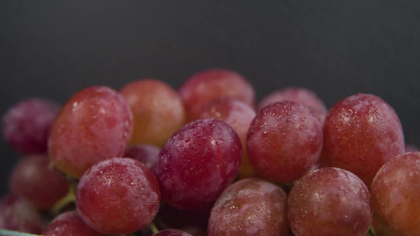 A close up of red grapes being sprayed with water