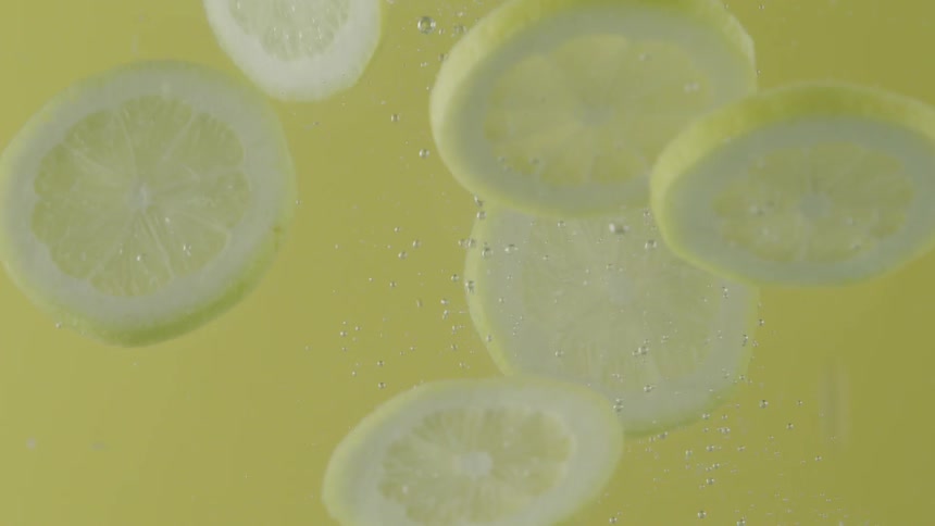 Slices of lemon being dropped into water
