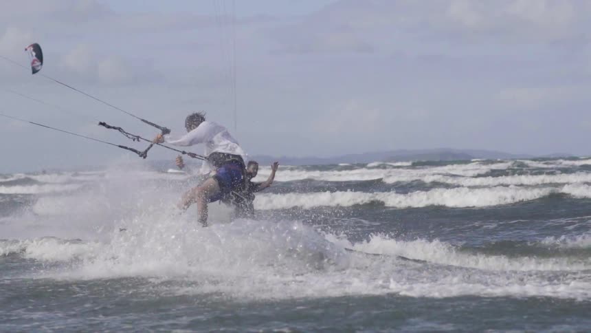 People are parasailing in the water on a cloudy day