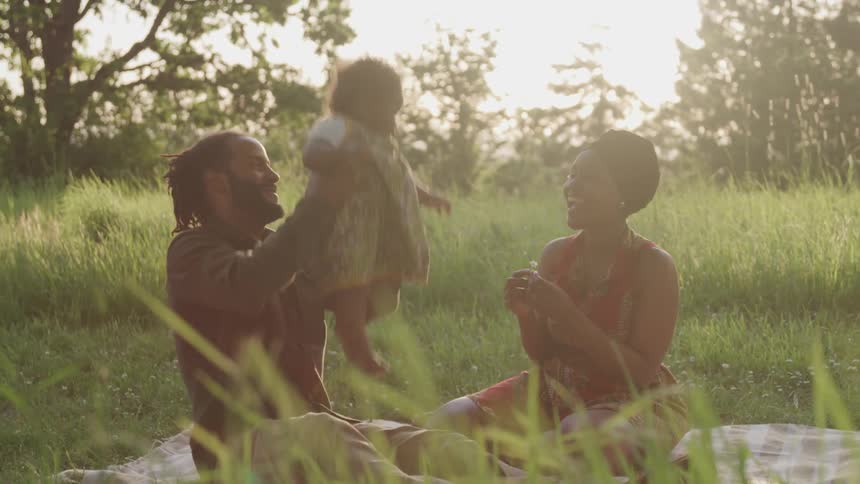 Mother father and daughter having a picnic in a field