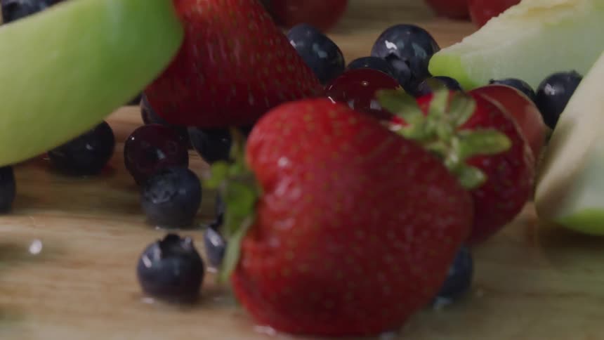 A variety of fruits falling onto a surface