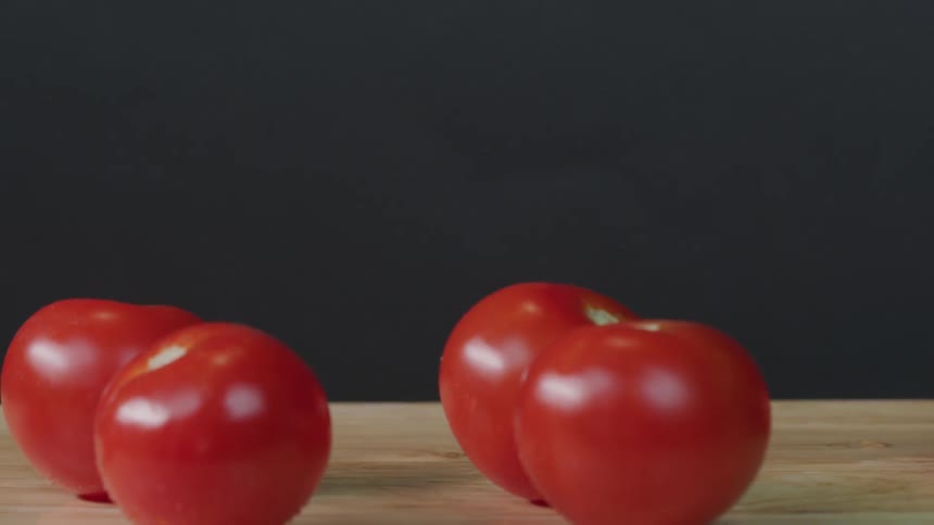 Tomatoes are being dropped onto a table