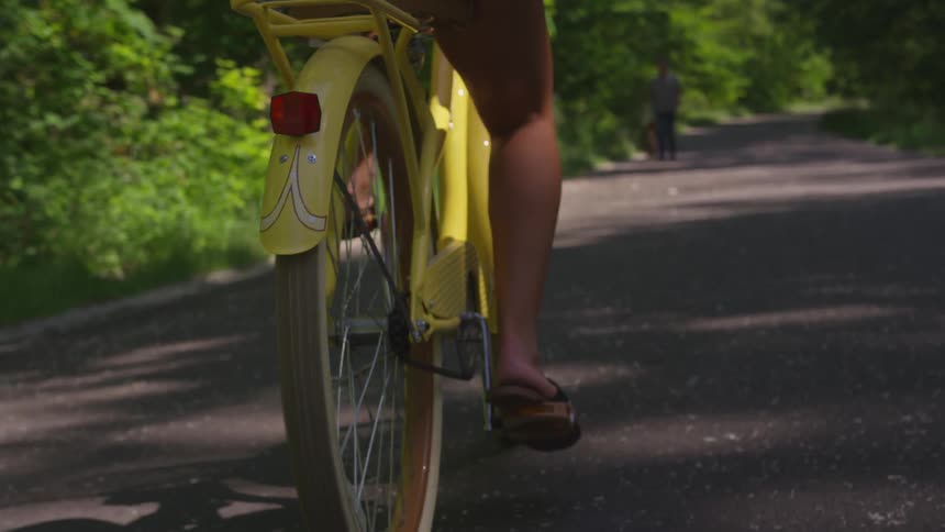 Yellow beach cruiser being ridden on path in the forest