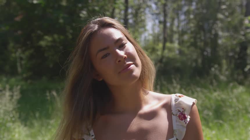 A young woman looks around a field