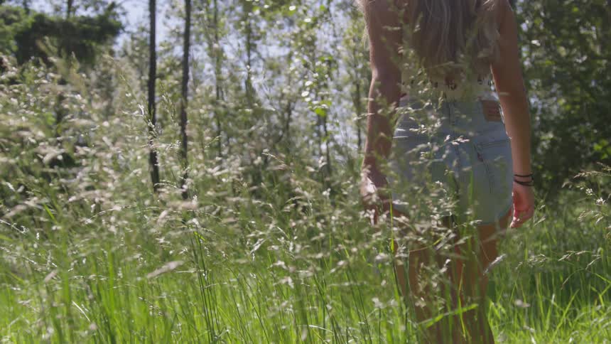 Blonde woman wearing mini shorts walk in the forest during daylight