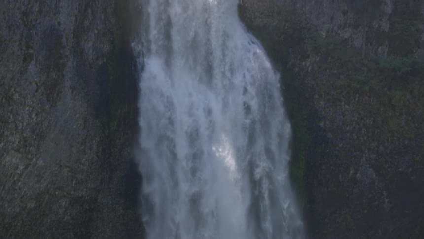 A waterfall in a forest on a sunny day