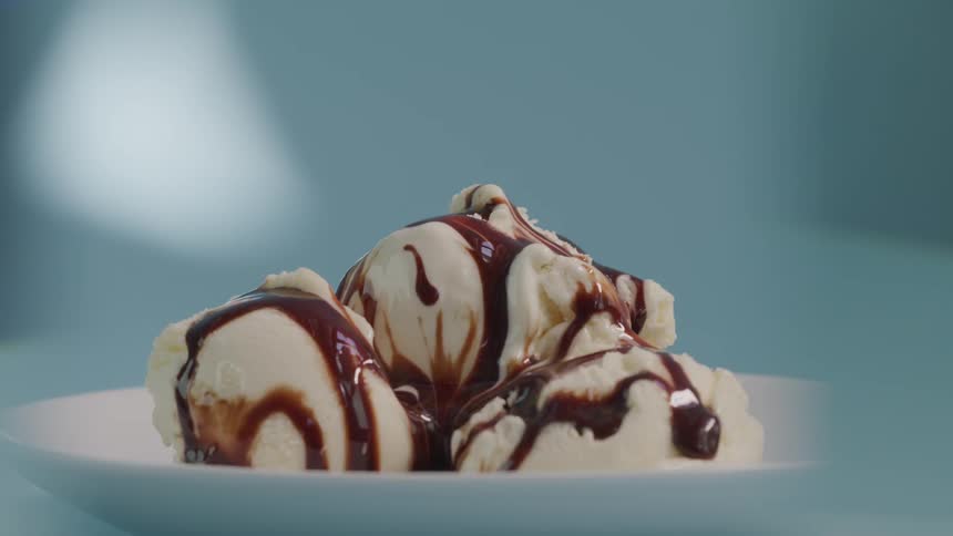 Fudge syrup drips down vanilla ice cream