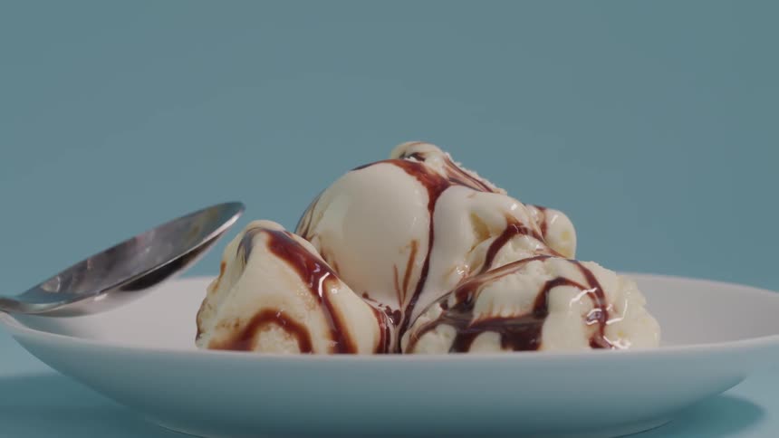 A bowl of ice cream with chocolate sauce on it