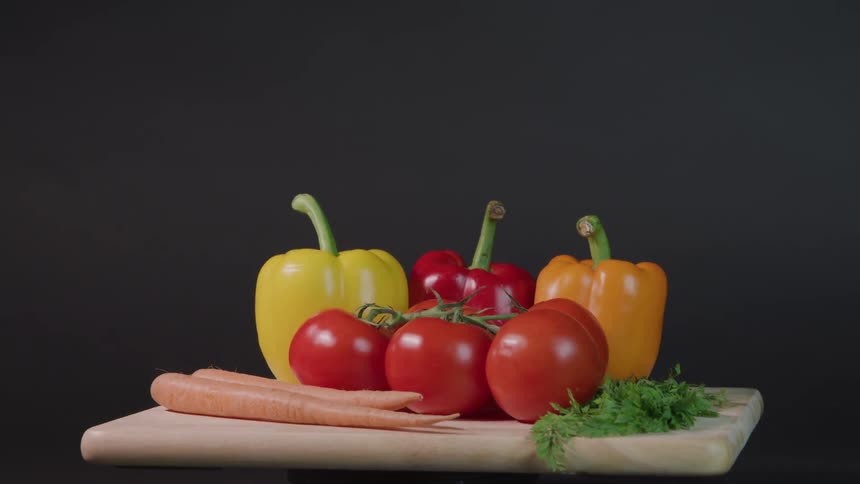 Peppers carrots tomatoes and herbs sit on a rotating table