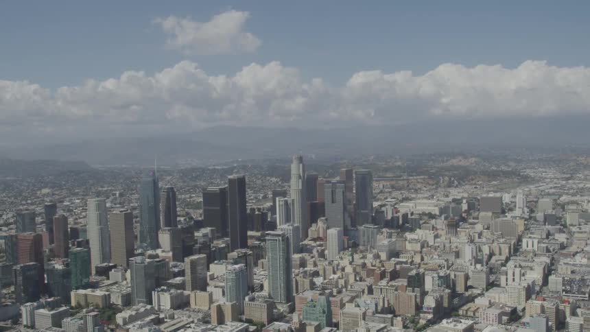 Haze and clouds cover mountains and horizon behind city
