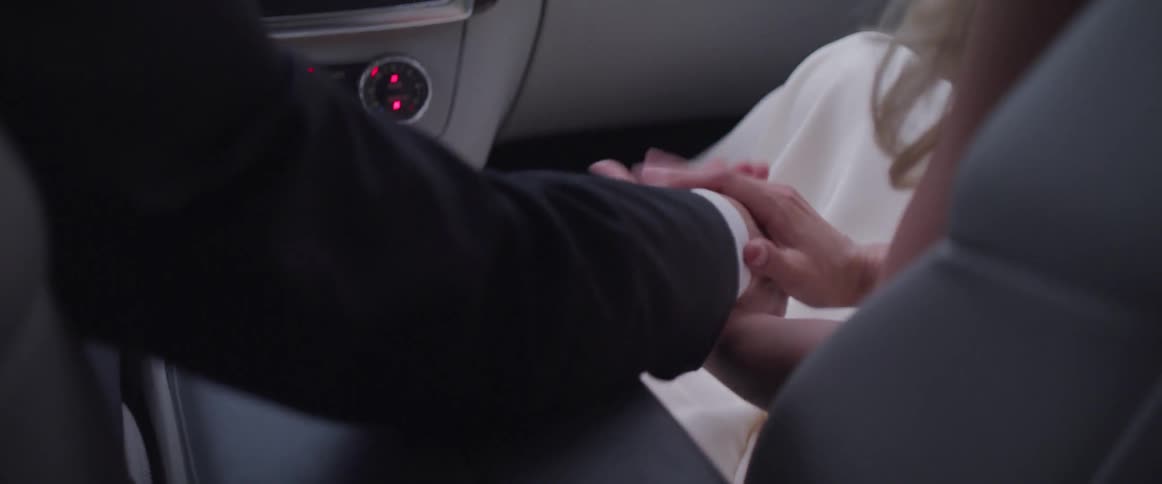 A couple holding hands in the car