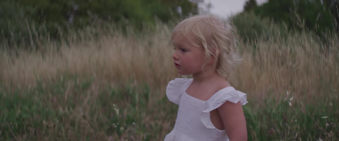 A girl standing on a grassy field