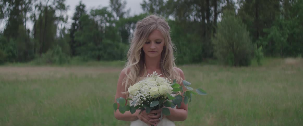 A woman is holding flowers outdoors
