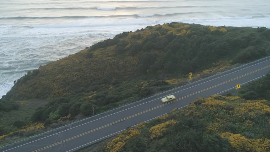 A car driving on a road near the coast