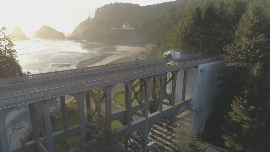 A car drives over the bridge near the shore