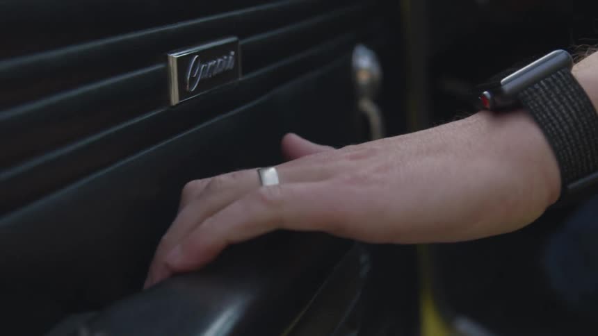 A person pulls a car door closed