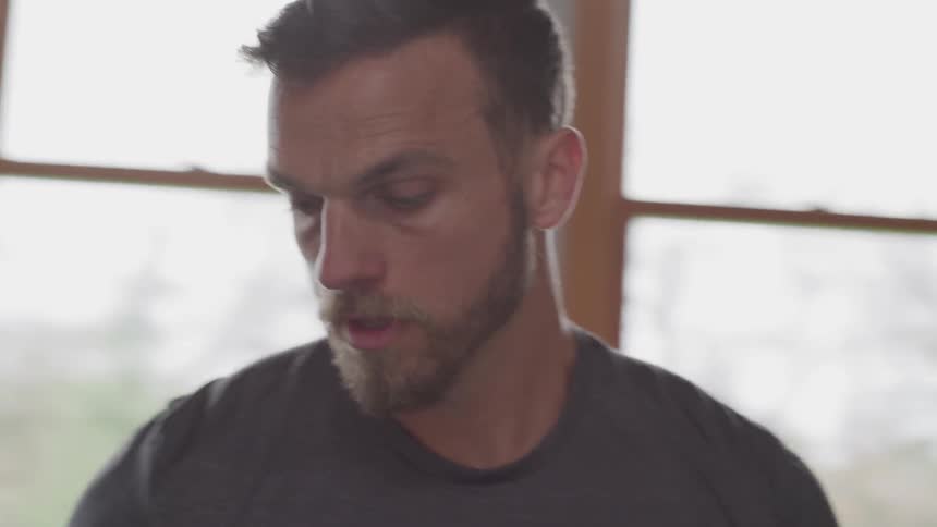 Man stands in a room containing workout equipment