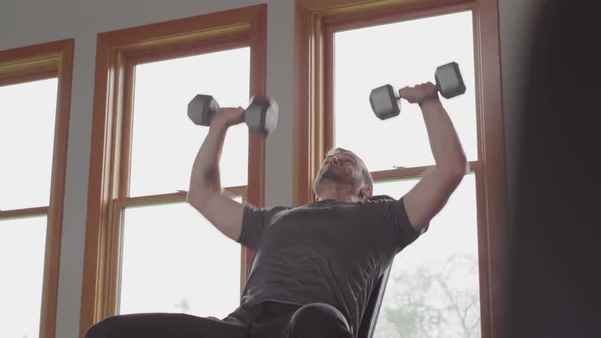 Man working out with weight lifting at the gym