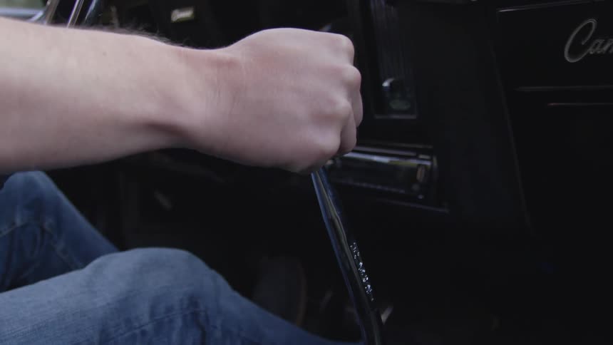 A man shifts gears while driving