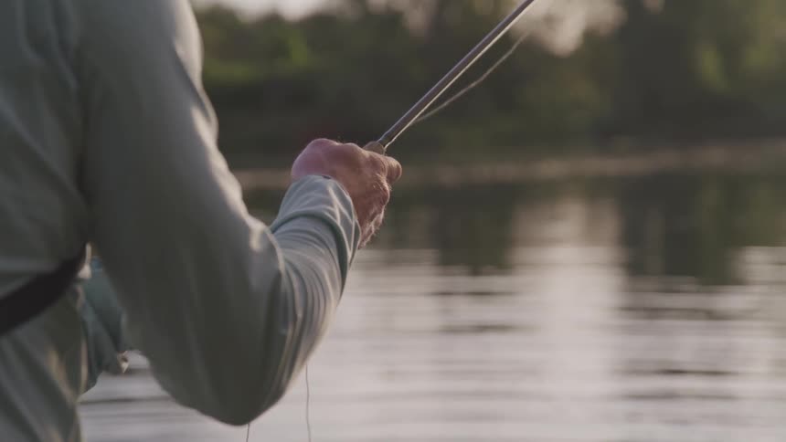 A person casts a fishing line and pulls the slack