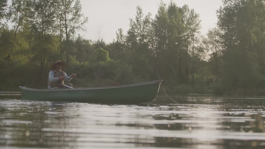 A person is in a boat outdoors fishing