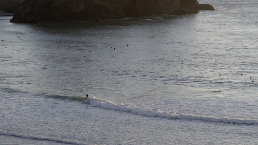 A group of surfers navigate ocean waves, sharing the water and enjoying the surf.