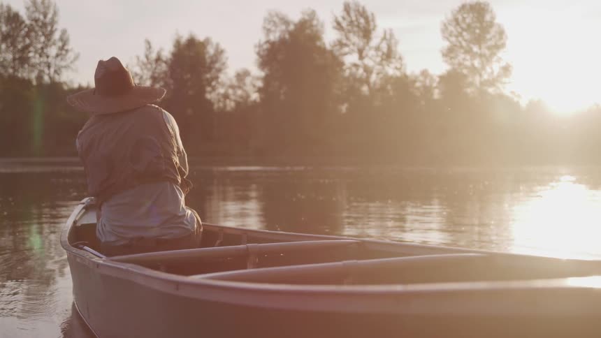 A man sitting on a boat fishing