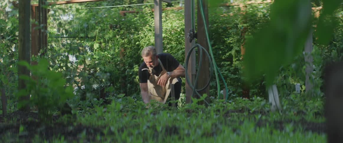 A man digs in the dirt with a small hand shovel
