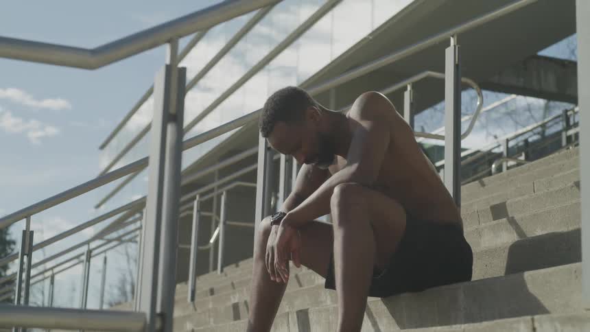 Man sit and rest on the stairs after exercising