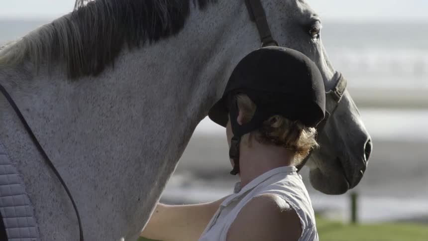 A Woman Gently Caring for Her Horse After a Ride, Showing Calm Affection.