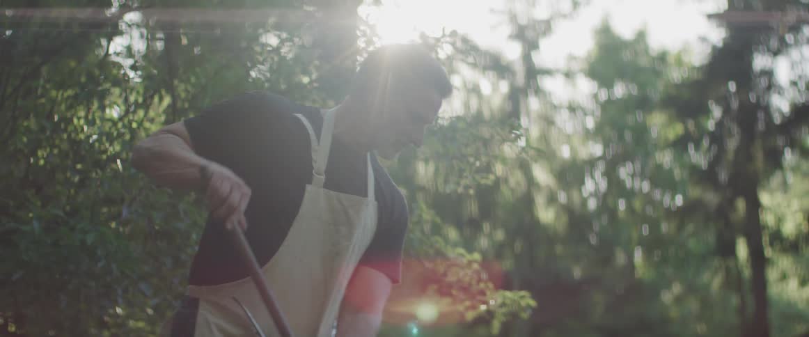 Man raking up items outside