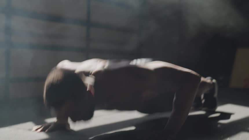 Man doing push up at the building near a foggy window