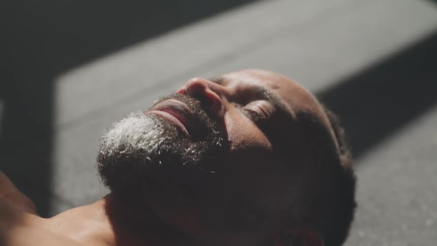 A man is laying on the ground breathing heavy