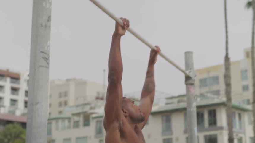 A man does pull ups in a public area