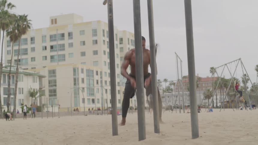 Black man doing exercise at the beach on a cloudy days