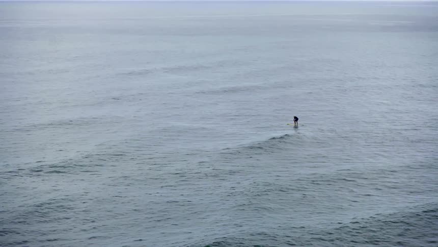 A person paddle boarding on a large body of water