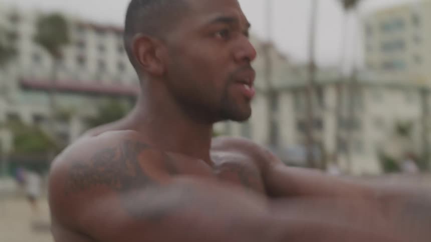 Black man exercising heavily at the beach