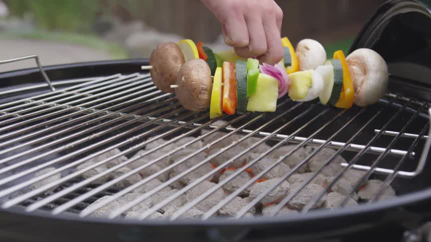 Vegetable kabobs are cooked on an outdoor charcoal grill