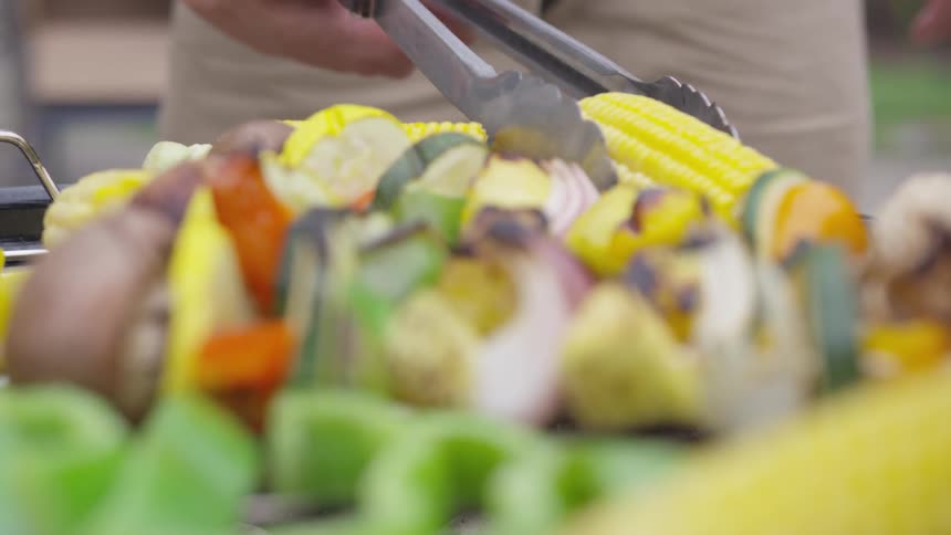 A person turning over food on a grill