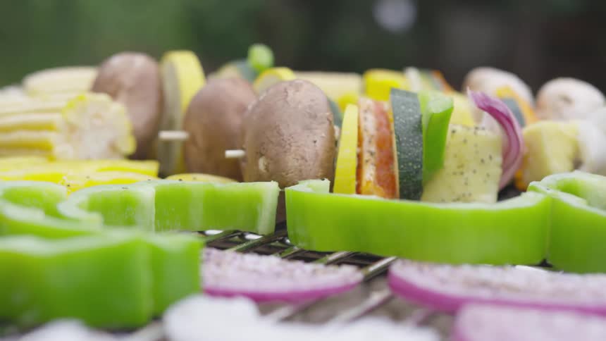 Vegetables and kabobs cooking on a grill