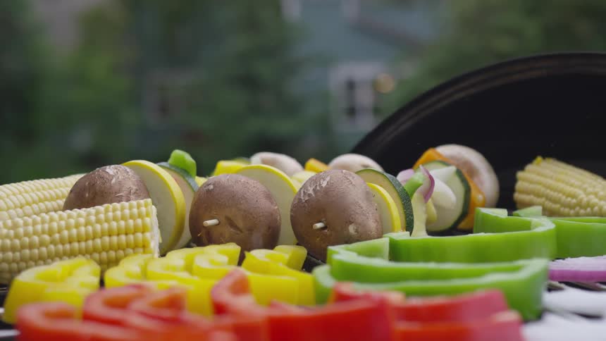 A person is seasoning vegetables outdoors