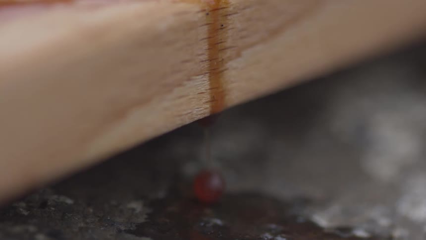 Liquid drips off of a piece of wood