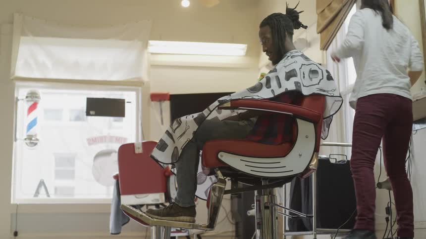 Women cutting a mans hair
