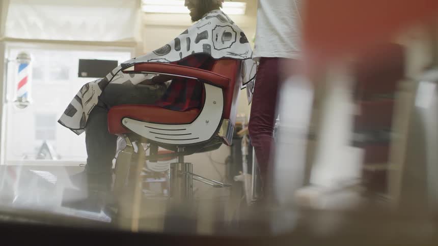 Person shaves mans neck in barbershop