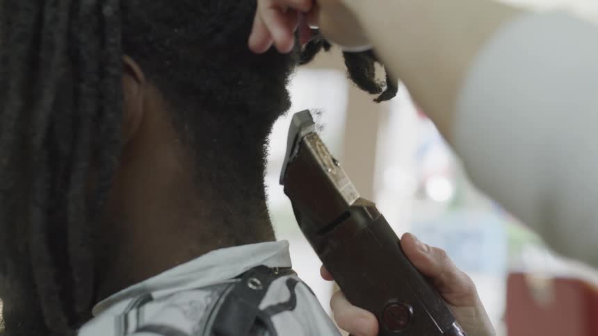 Woman shaves the hair on the back of a mans head