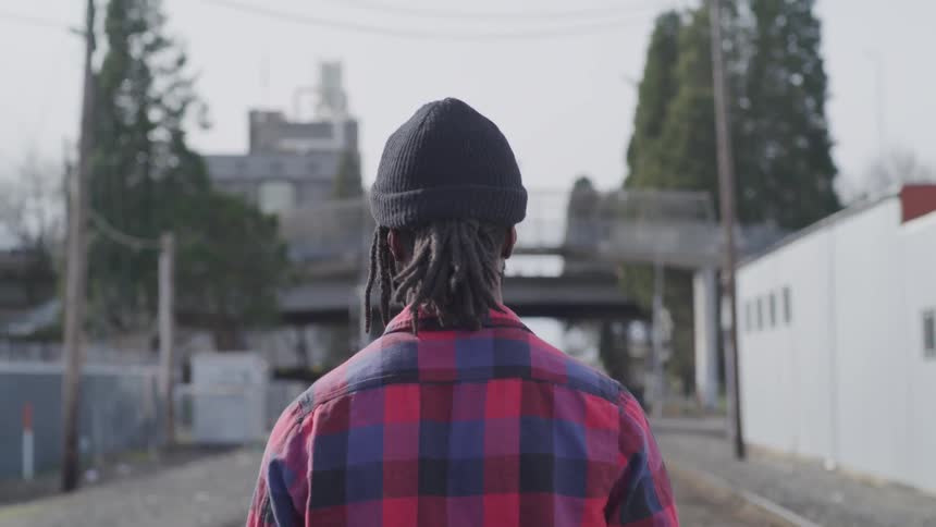 A person walks down train tracks in a city
