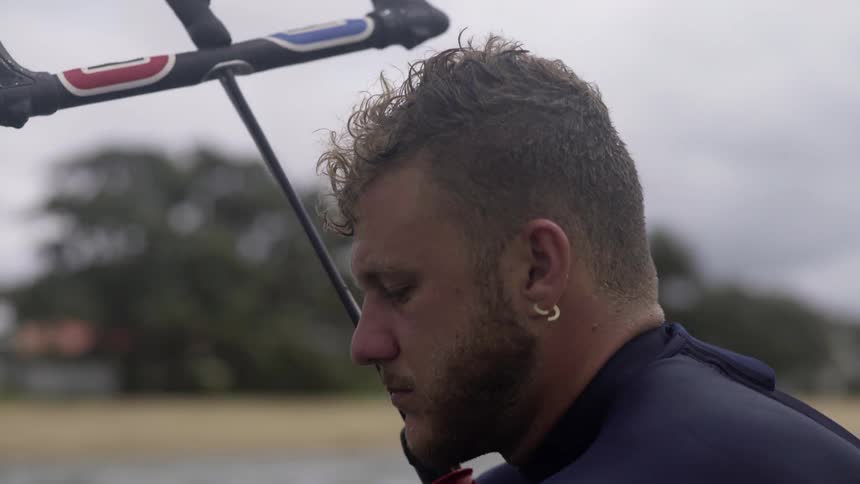 Man with earring checking equipment on the lake