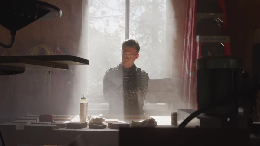 A man is standing in a workshop indoors