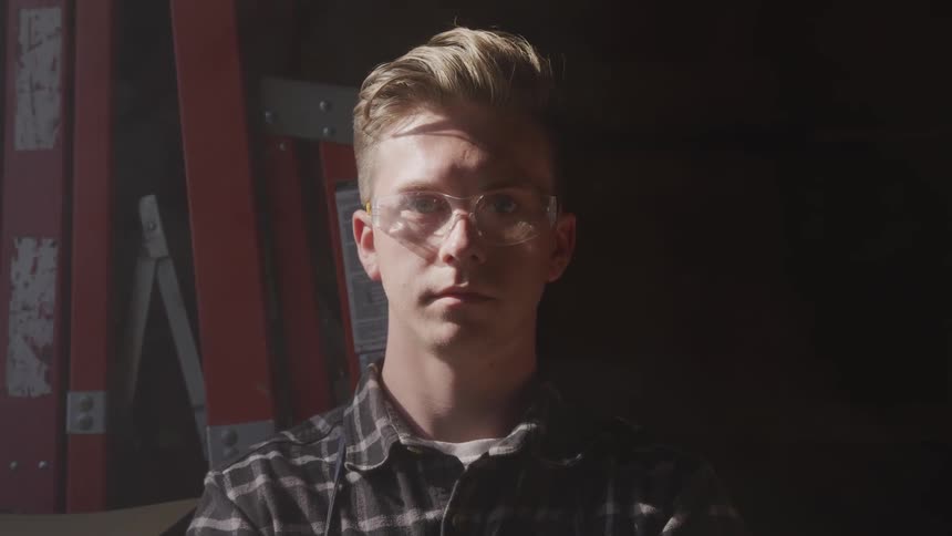 A young man stares at the camera